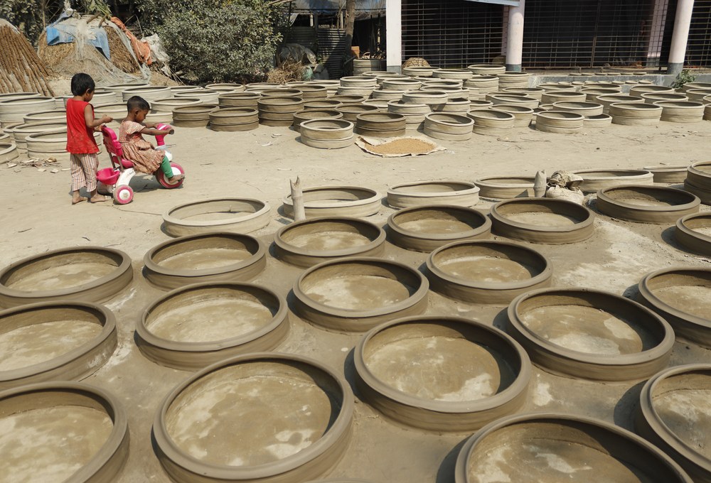 Shelves of greenware pottery air drying in workshop